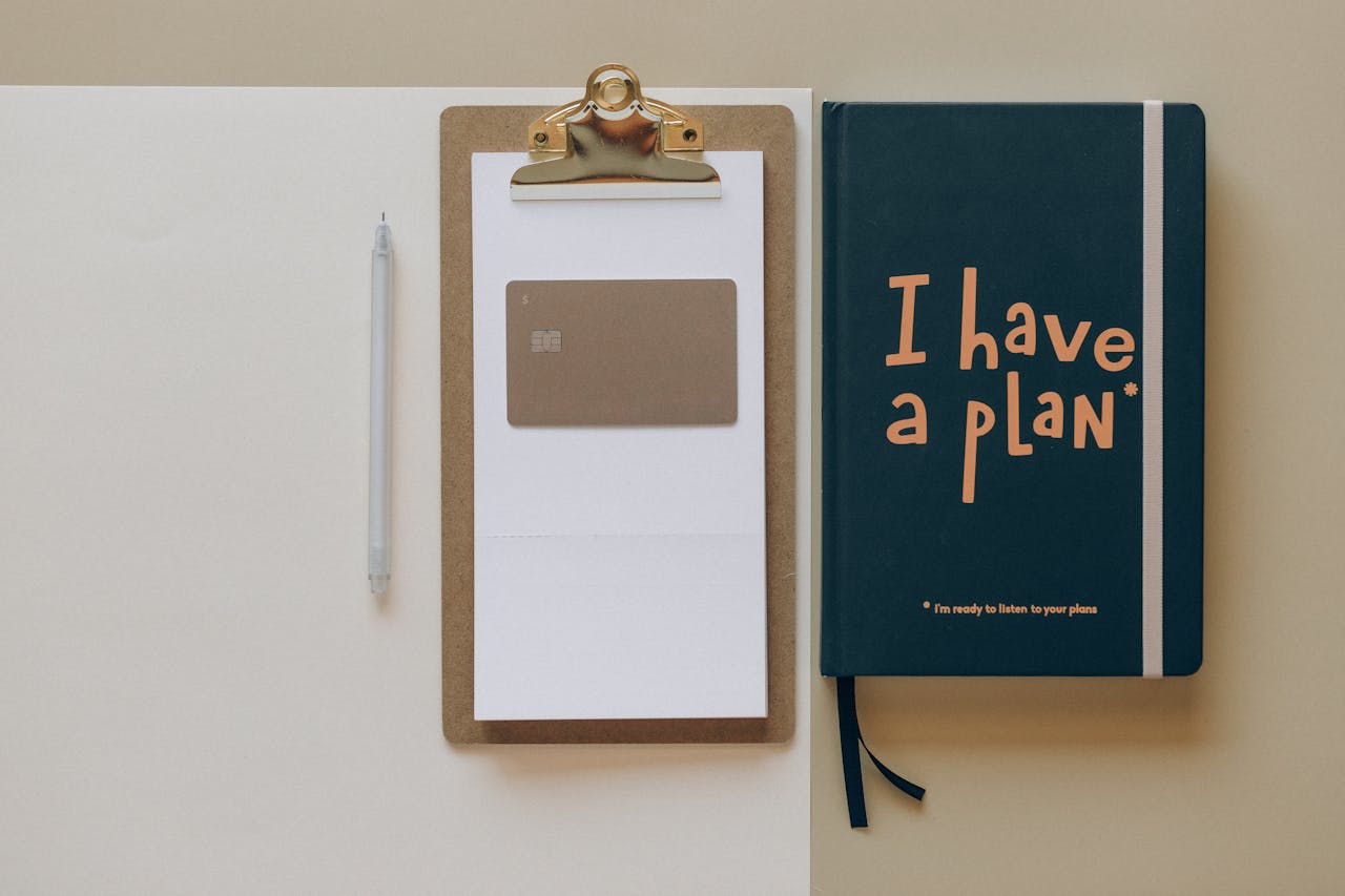 services-04 A minimalist office setup featuring a planner, clipboard, card, and pen, perfect for planning and organization.